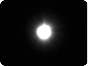 Fondo negro con una luz brillante en el medio que representa la medición de halo del banco óptico para la LIO AcrySof® IQ Monofocal.