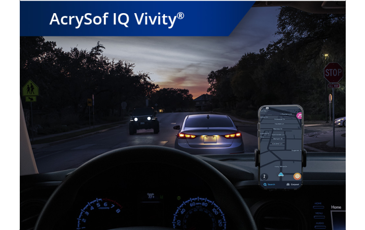 Un coche en una carretera con condiciones de poca luz con un teléfono montado en el salpicadero. Aparece un texto blanco en la esquina superior izquierda de esta imagen que dice: “AcrySof IQ Vivity.”